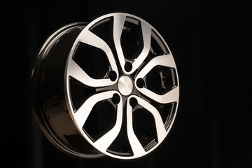 New alloy wheel of the car, close-up on a black background, wheel elements, two-color coating,...