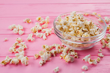 Fototapeta na wymiar Fresh popcorn bowl on pink background. Close up fast food. Flat lay picture.