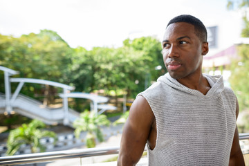 Fototapeta premium Young handsome African man thinking and ready for gym in the city