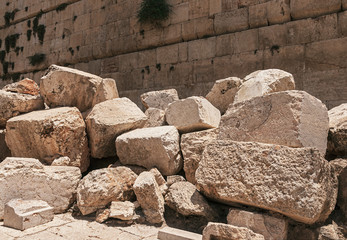 stones thrown by the romans from the second temple to the street below after the destruction of the temple in 70 CE with the Western Wall in the background - obrazy, fototapety, plakaty