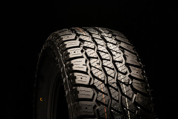 Fototapeta premium all terrain new tire close-up on a black background