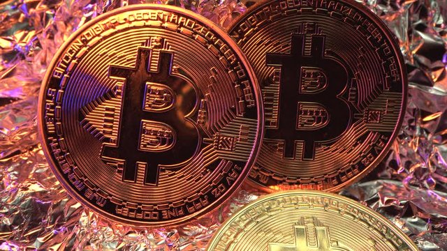 Three gold Bit Coin BTC are on the table. Light flash on the currency. Amazing Macro shot from LAOWA 24 mm. Halving. BITCOIN. 4K