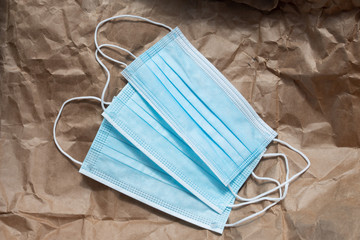 Blue antibacterial medical masks on craft paper. Coronavirus protection, health care and hygiene