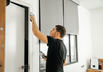 Portrait of a man making repairs in his apartment Putty and glossing over cracks on the wall....