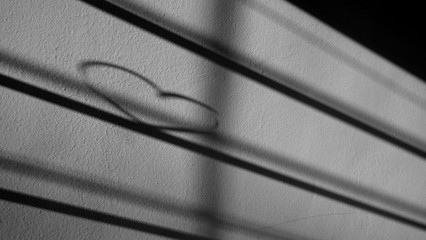 Modern blurred abstract background shadow of heart. Playing with sunlight. Valentine's day or love concept.
