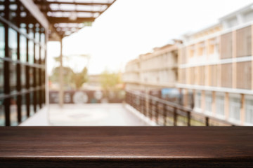 Empty wood table platform with bokeh light of city background for product presentation display montage.