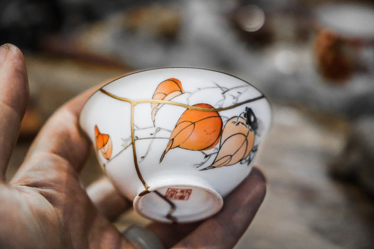 Kintsugi technique. Porcelain cup repaired with gold.