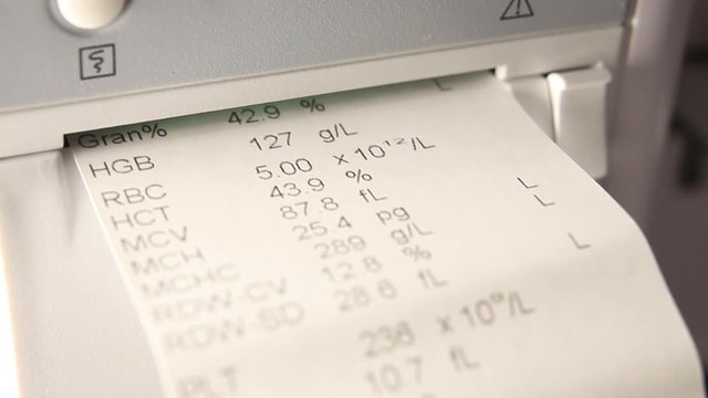 Blood test.A piece of paper with a printed blood test comes out of a blood test machine.Close-up.