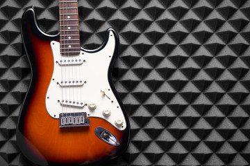 Fototapeta na wymiar Top view of electric guitar on acoustic foam panel background