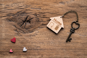 House key with home keyring decorated with mini heart on rusty wood background - 345332160