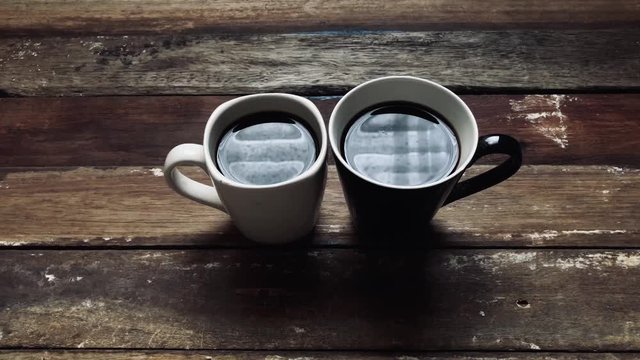 Espresso,black coffee in mug on empty old wood table top,dimly light,with lens flare,free space for text design.2 Coffee cup for couple of love,friend etc.Concept of Relaxation in Coffee time.
