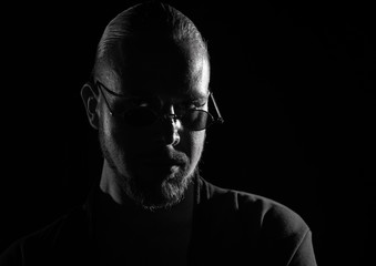 Portrait of a man in glasses on a dark background