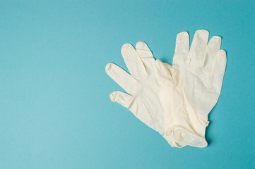 Fototapeta na wymiar Pair of latex medical gloves isolated on blue background, coronavirus and infection protection.