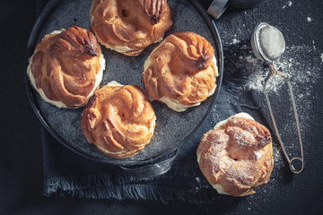 Small and fresh cream puffs with powdered sugar