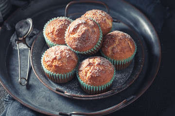 Sweet and hot vanilla cupcakes on rustic dark table