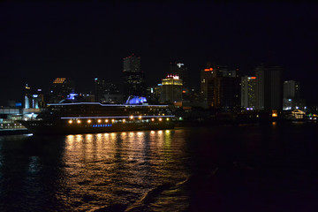Fototapeta na wymiar night panorama with cruise ship near town. night light on cruise ship
