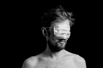 portrait of a guy on a black background, a mask on his eyes