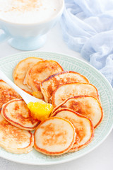 Homemade curd pancakes for breakfast with cappuccino, selective focus