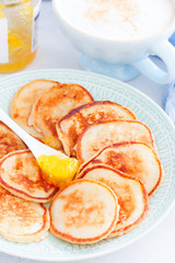 Homemade curd pancakes for breakfast with cappuccino, selective focus