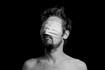 portrait of a guy on a black background, a mask on his eyes