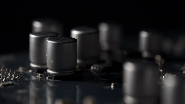Macro View of Electronic Circuit, Microchips, 
Transistor and Capacitor on Computer Mother Board with Lights and Shadows Moving. 4k