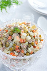 Classic festive salad Olivier with beef in a crystal salad bowl, selective focus