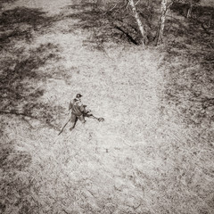 a man with a metal detector on an ancient settlement photographed from a drone