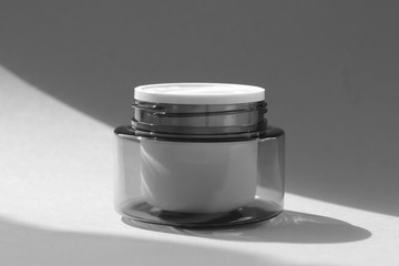 Flat lay face and body cream in a jar. Beauty background with facial cosmetic products.