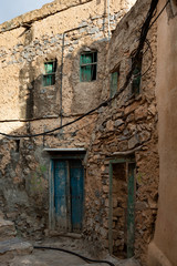 Fototapeta na wymiar Ruins of old Misfat al Abriyeen in Oman with blue wooden door