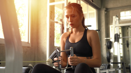 Young beautiful woman doing exercises with weight training