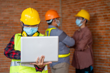 Engineer women wear protective face masks for safety Coronavirus Disease 2019 (COVID-19) use laptop for work at construction site,Coronavirus has turned into a global emergency.
