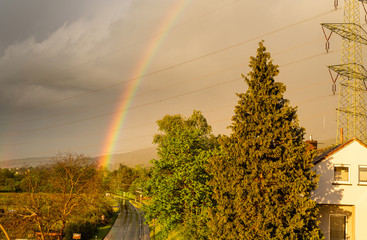 Colorful rainbow in the sky. Storm weather. Cloudy sky. Areas outside the city. End of rain. Spring...
