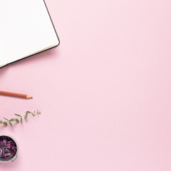 Work and study place, empty notebook and colored pencil with dry flowers on pink background. flat lay, top view, copy space