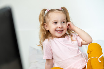 Fototapeta premium Happy little girl whith headphones at home