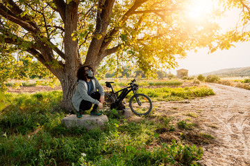 Obraz premium Man with surgical mask in the field with his bicycle
