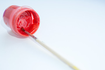 plastic jar with red paint and brush