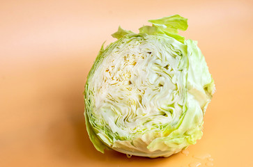 Fototapeta premium Cabbage cut in half on a yellow background