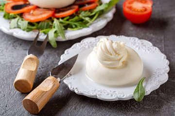 Fresh Italian cheese made from cow's milk - burrata on a white plate.Close up. Salad on a plate.