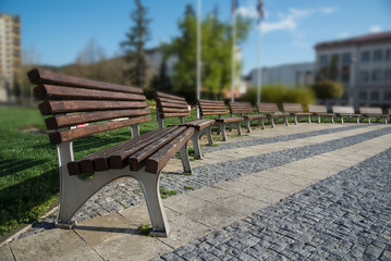 Fototapeta na wymiar Wooden and metal benches on the town in summer