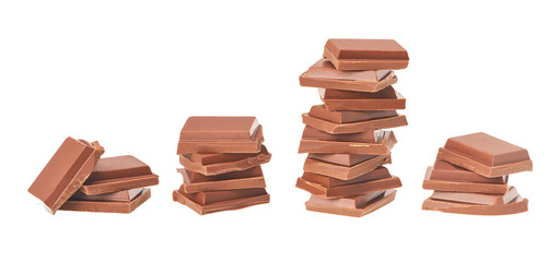 milk chocolate pieces tower isolated on white background.