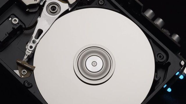 Macro, Close-Up of Computer Hard Disk Drive Spinning and Writing. Blue Lights Blinking. 4k
