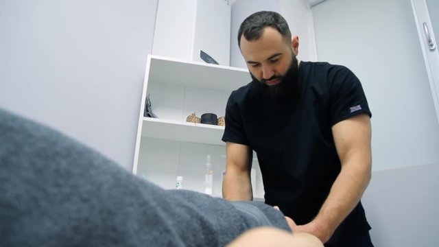 The doctor massages the woman in the hospital