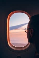 Man looking throught window of airplane