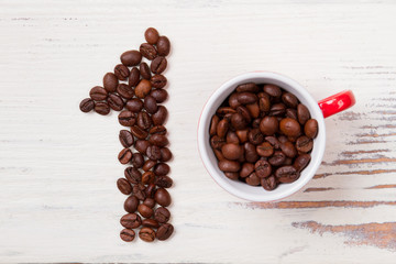 Number one coffee. Flat lay filled cup with coffee grains. Number one made of beans on white wood.
