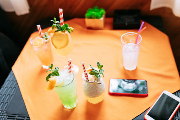 five non  Alcoholic  summer Cocktail. Alcoholic beverage based on table with ice cubes and oranges.