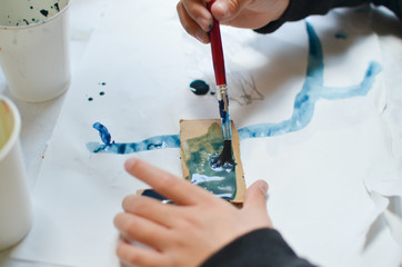 children painting with watercolor on a corrugated carton