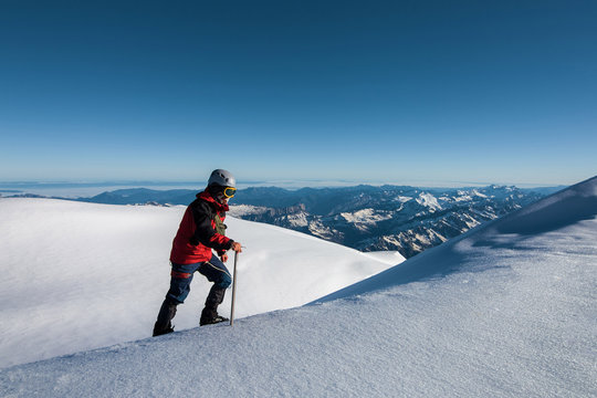 Climber In A Red Jacket Climbs A Mountain