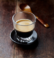 Coffee in glass cup on rustic wooden  background. Close up. 