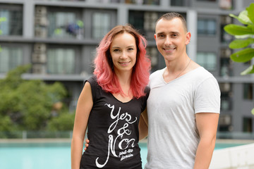 Naklejka premium Portrait of happy couple smiling together in the swimming pool area