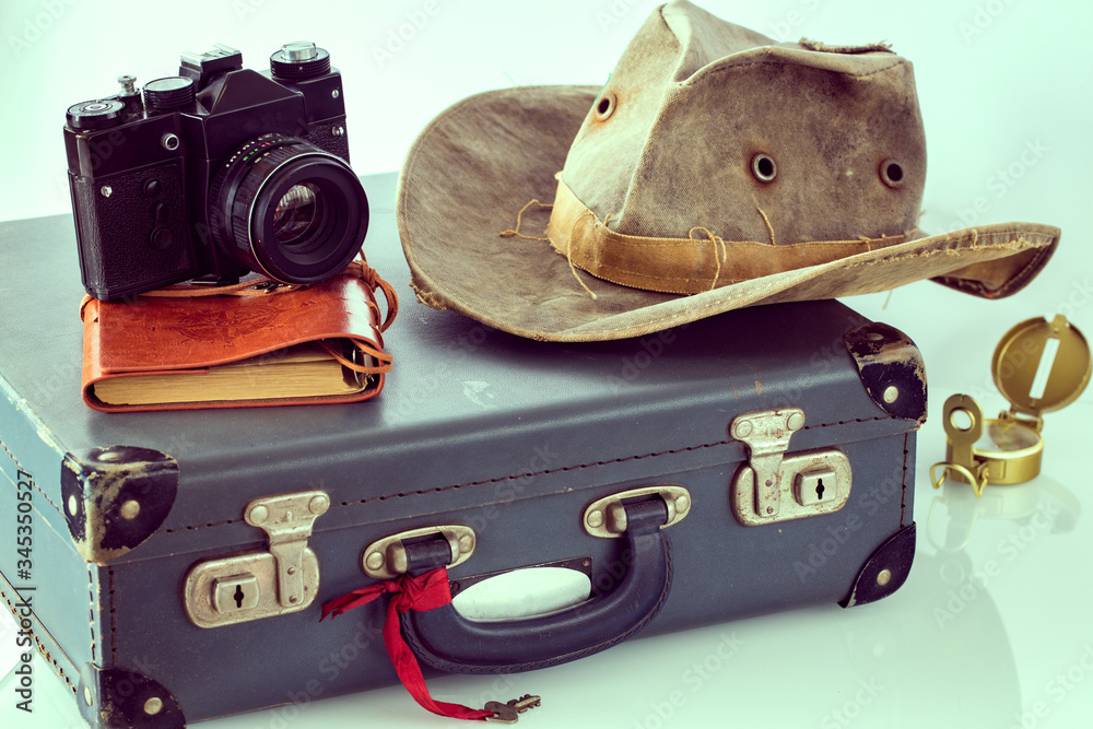 Fototapete old-style suitcase, camera, travel hat, notebook, map, retro style compass. the concept of preparing